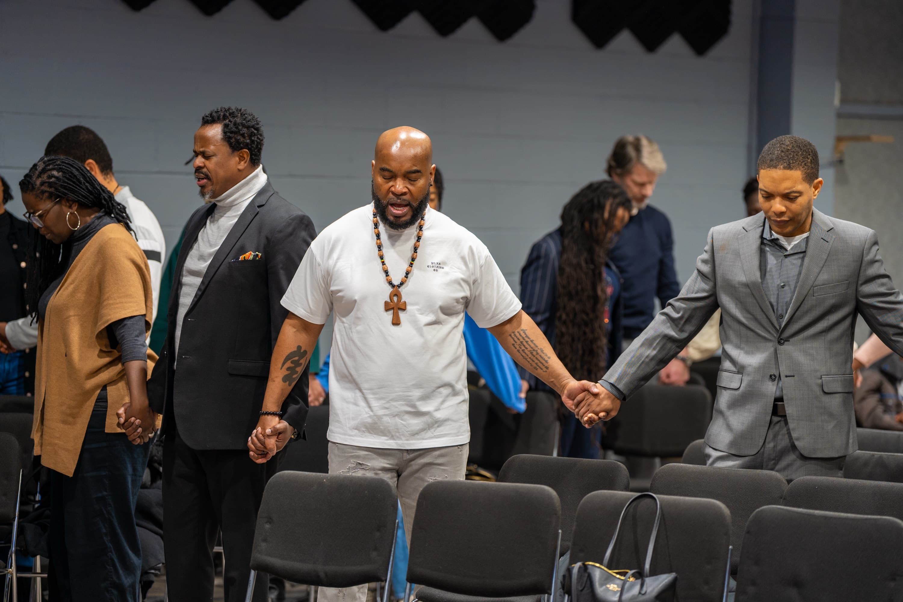 KCLC congregation holding hands in prayer
